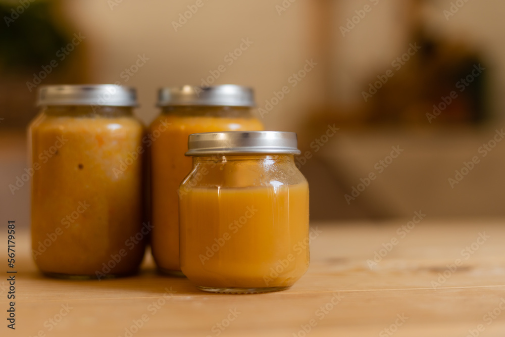 baby vegetable and fruit puree in jars in the kitchen, mockup. Baby food, space for text. Jars of baby food on a wooden table baby vegetable and fruit puree in jars in the kitchen, mockup. Baby food, space for text. Jars of baby food on a wooden table