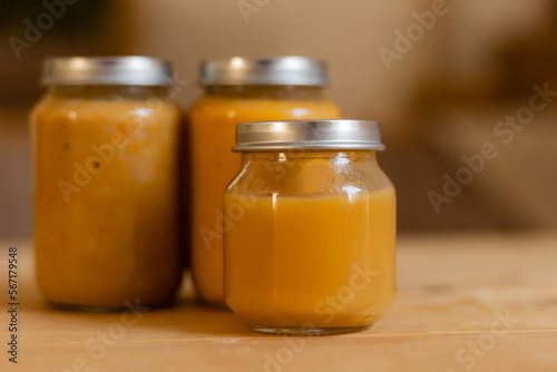baby vegetable and fruit puree in jars in the kitchen, mockup. Baby food, space for text. Jars of baby food on a wooden table