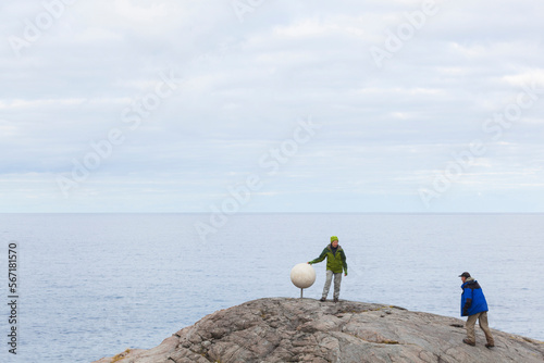 HIkers discover a sculpture of Saturn on Bunes Beach, Moskenesoya, Lofoten Islands, Norway. photo