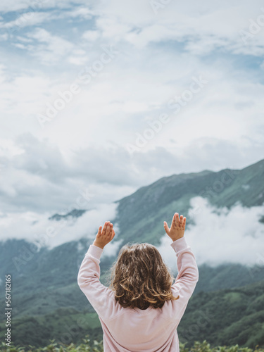 Little girl enjoying nature on the mountain photo