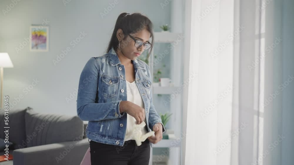 Indian woman takes off rubber glove after cleaning house throwing to garbage and going away. Young housewife takes care of personal hygiene at home Indian woman takes off rubber glove after cleaning house throwing to garbage and going away. Young housewife takes care of personal hygiene at home