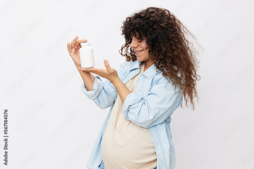 Pregnant woman smile with teeth jar of pregnancy vitamin pills in hands, alpha lipoic acid, vitamin complex Pregnant woman smile with teeth jar of pregnancy vitamin pills in hands, alpha lipoic acid, vitamin complex