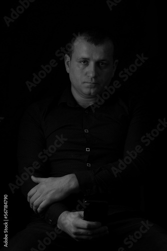 Black and white photo of a man in a shirt on a black background