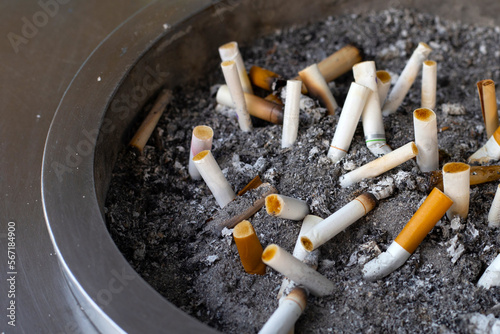 Cigarettes and ash on dirty sand in trash tray