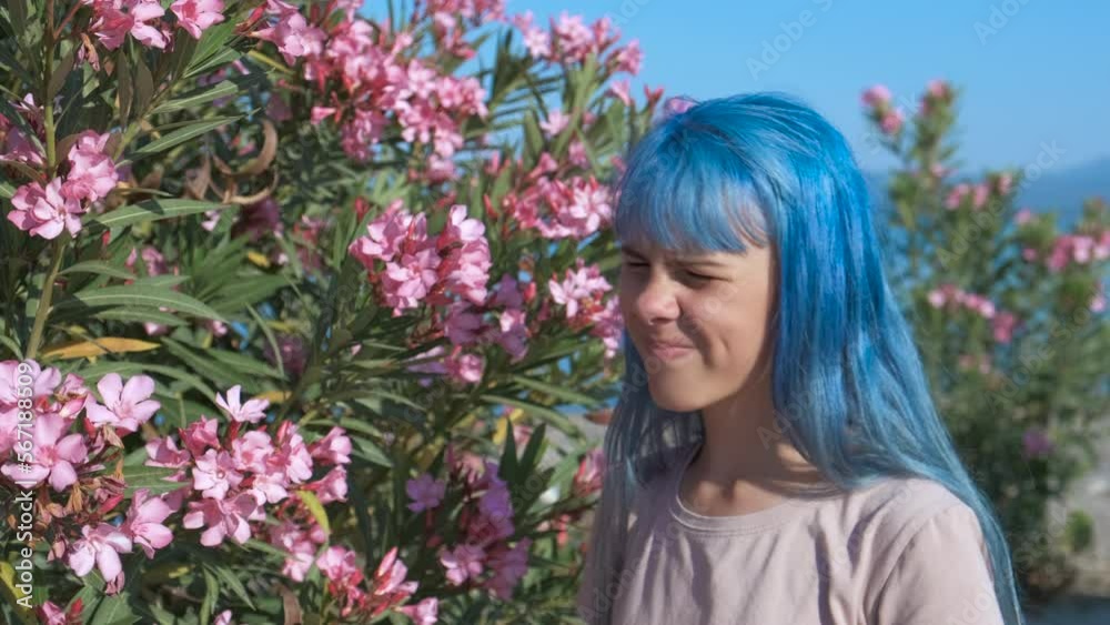 Pollen in the eyes. A girl in the park next to the flowers scratches her itchy eyes. Pollen in the eyes. A girl in the park next to the flowers scratches her itchy eyes.
