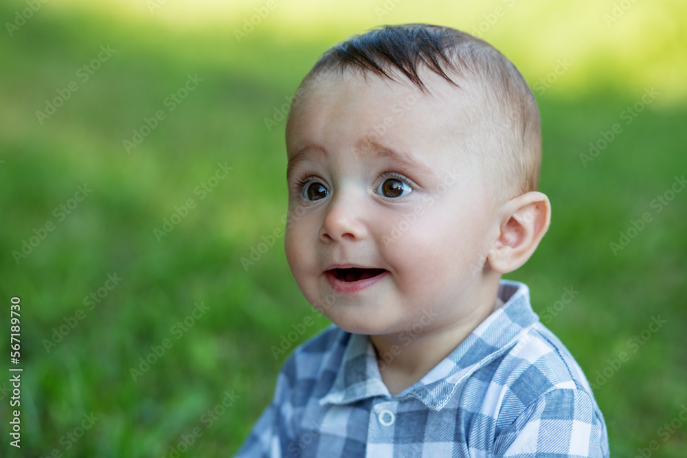 Portrait of little smiling boy in park. Close-up. Toddler boy walks in park. Brown eyes. Portrait of little smiling boy in park. Close-up. Toddler boy walks in park. Brown eyes.