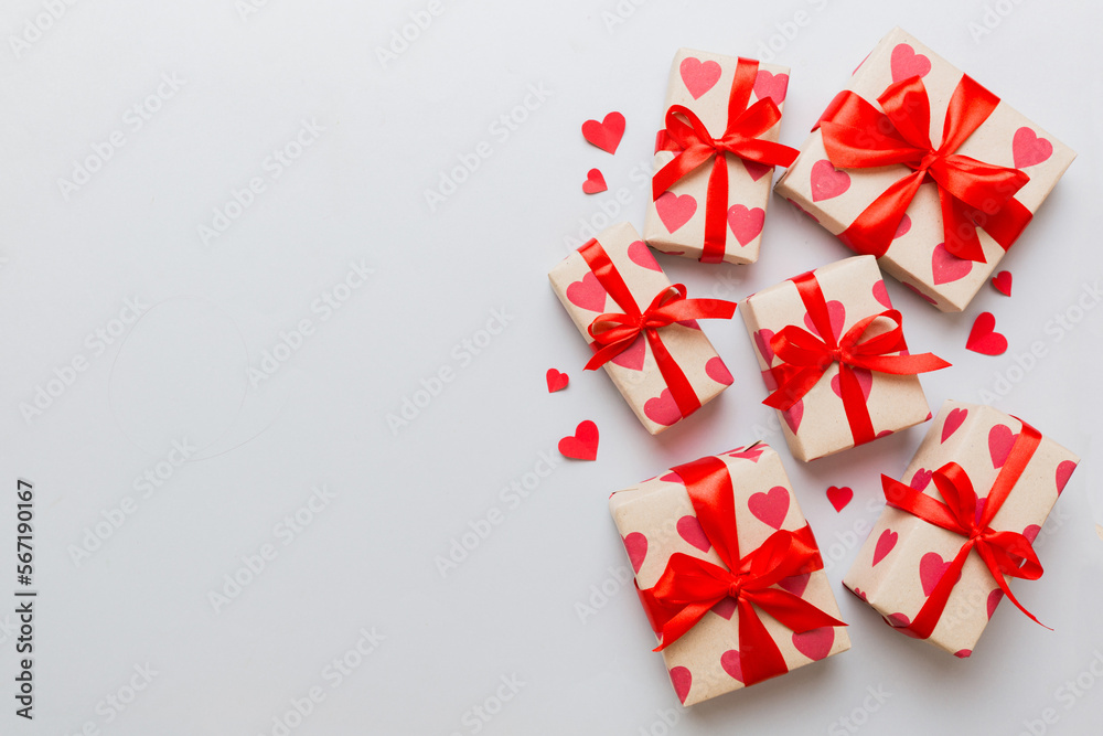 Top view photo of valentine day decorations gift box with red ribbon bow on colored background. Holiday gift boxes with top view Top view photo of valentine day decorations gift box with red ribbon bow on colored background. Holiday gift boxes with top view