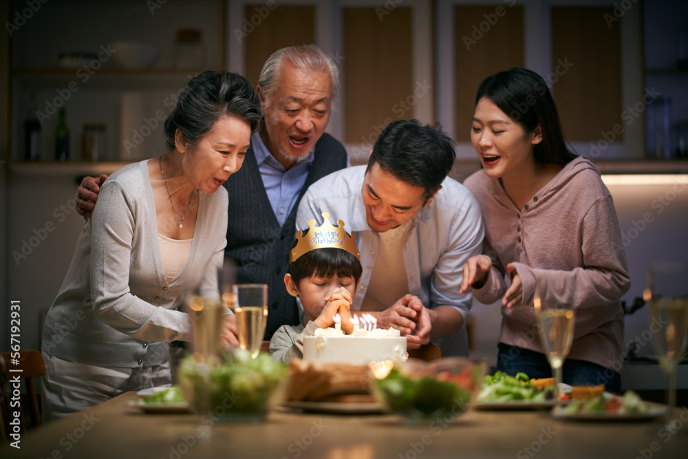 three generation asian family celebrating little boy's birthday at home