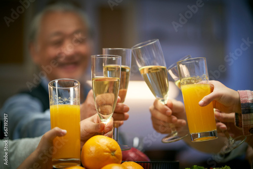 elderly asian man having a toast with family at dinner