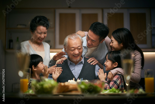 three generation asian family celebrating grandpa's birthday at home