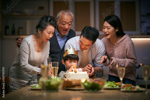 three generation asian family celebrating little boy s birthday at home