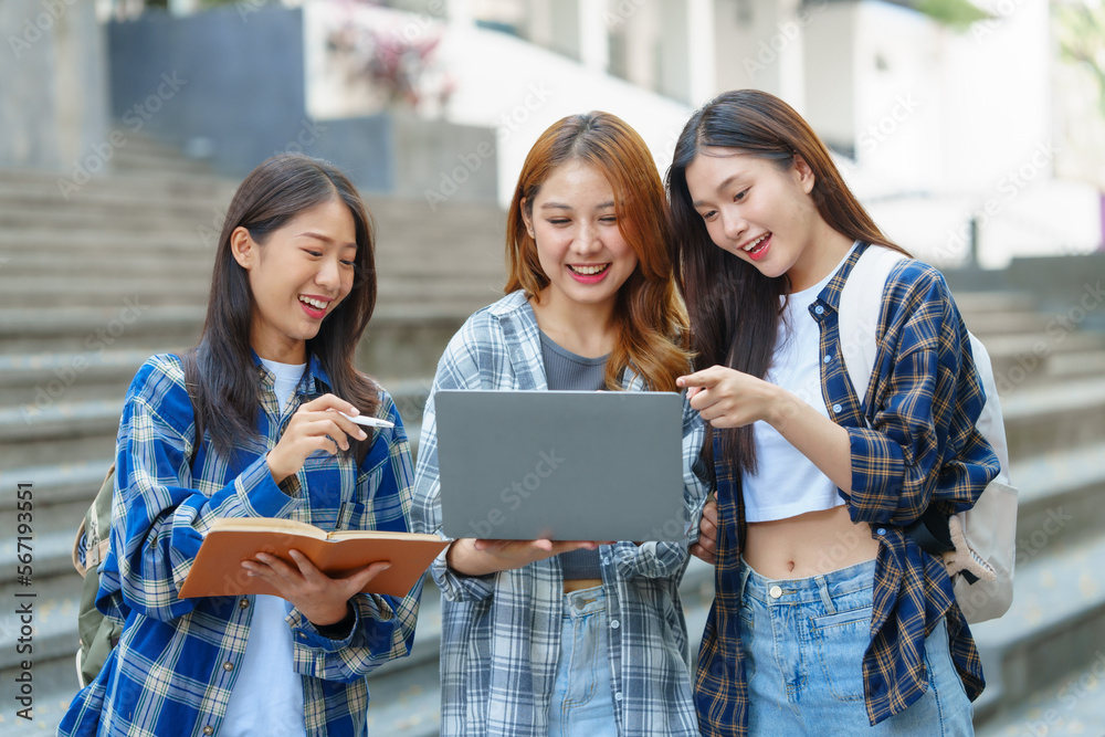 Attractive asian college student using laptop and tablet studying with group of friends together with english language classroom, social media and education concept. Attractive asian college student using laptop and tablet studying with group of friends together with english language classroom, social media and education concept.