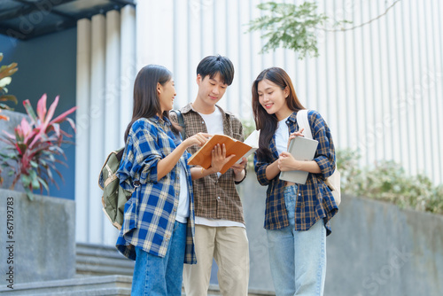 Attractive asian college student using laptop and tablet studying with group of friends together with english language classroom, social media and education concept.