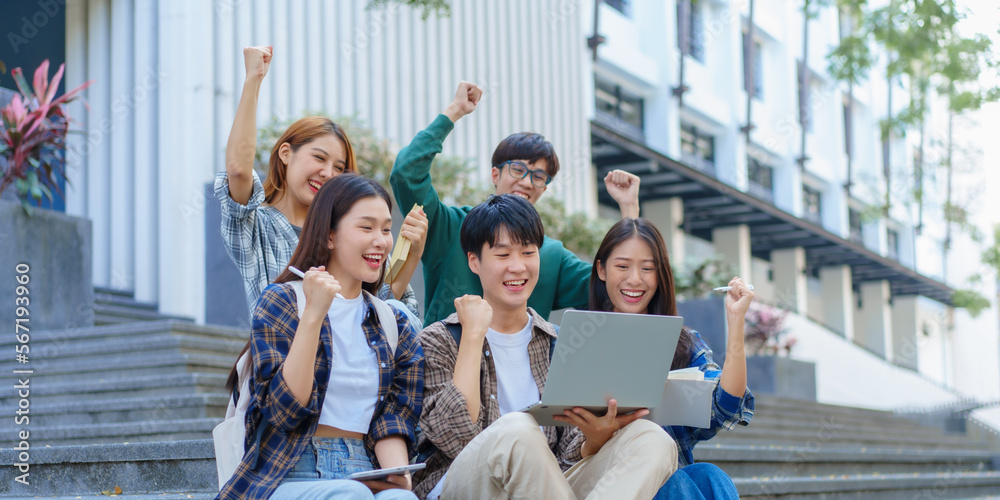 Fototapeta premium Attractive asian college student using laptop and tablet studying with group of friends together with english language classroom, social media and education concept.