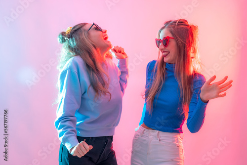 Two young blonde caucasian women dancing in nightclub, having a lot of fun party dancing