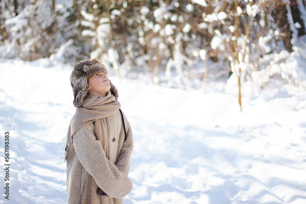 oy in warm hat in a snowy forest oy in warm hat in a snowy forest