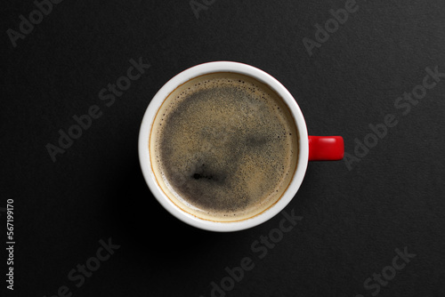 Ceramic cup with hot aromatic coffee on black background, top view