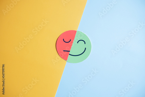 Happy smiley face hiding or behind sad face, change emotion bipolar and depression, mental health concept, personality, mood change, therapy healing split concept... photo