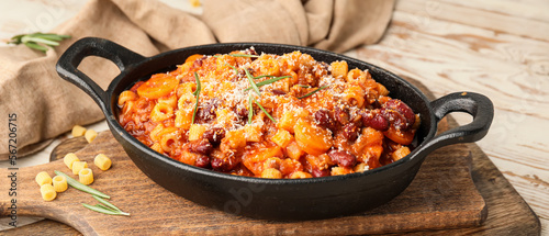 Dish with tasty pasta and beans on table photo