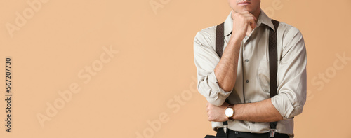 Schilderij op canvas Fashionable gentleman with suspenders on beige background with space for text