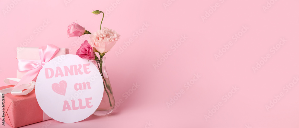 Card with text DANKE AN ALLE, gifts and eustoma flowers on pink background with space for text