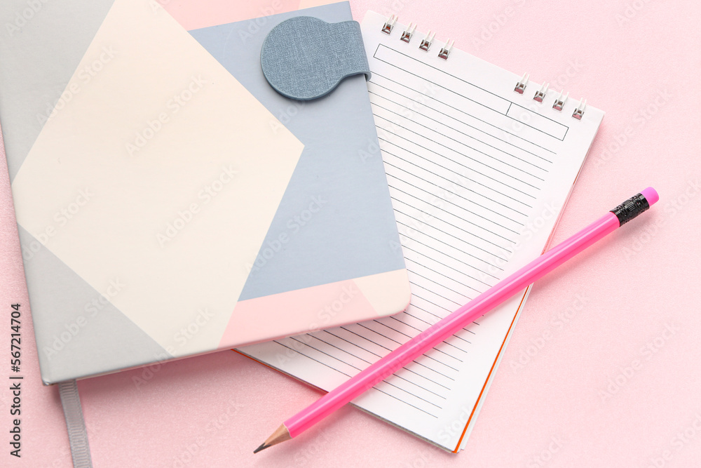 Notebooks and pencil on pink background, closeup Notebooks and pencil on pink background, closeup