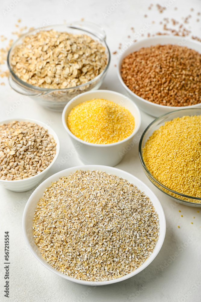 Bowls of different cereals on light background, closeup Bowls of different cereals on light background, closeup