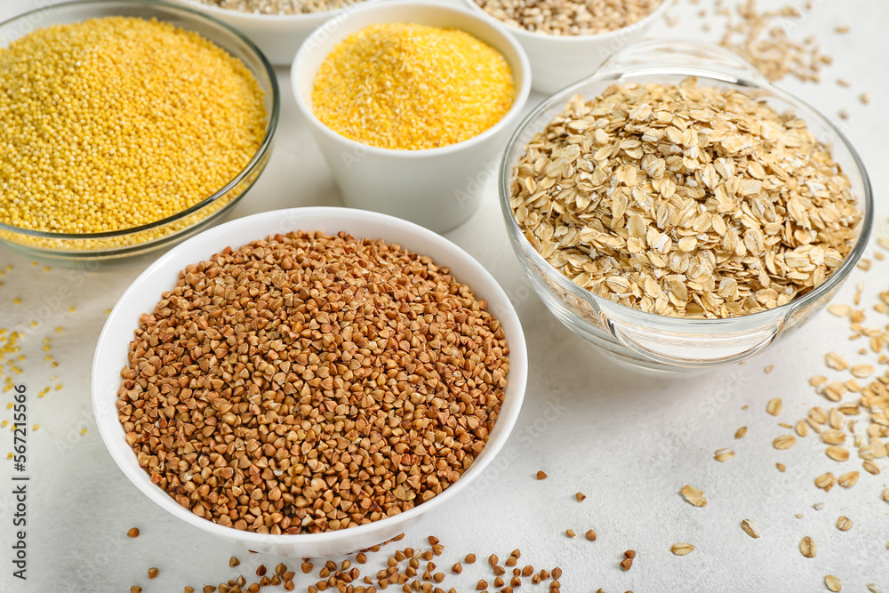 Bowls of different cereals on light background, closeup Bowls of different cereals on light background, closeup