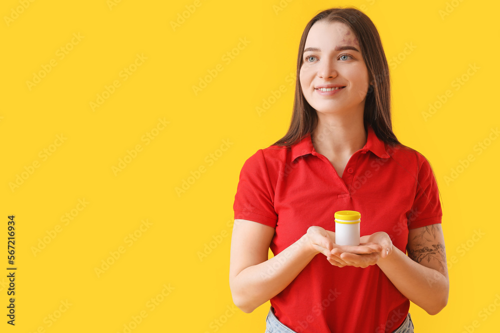 Young woman with bottle of vitamin supplements on yellow background Young woman with bottle of vitamin supplements on yellow background