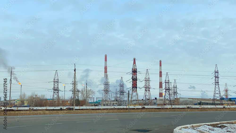 Gas processing plant. View of gas flares and striped pipes of a thermal power plant. Air pollution and ecology. Gas processing plant. View of gas flares and striped pipes of a thermal power plant. Air pollution and ecology.