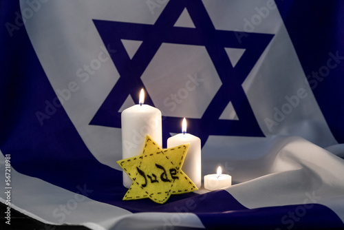 Jewish badge and burning candles on flag of Israel. International Holocaust Remembrance Day photo