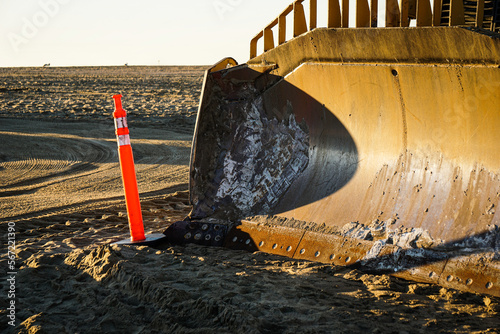 Bulldozer on beach sand with safety cone #567221390