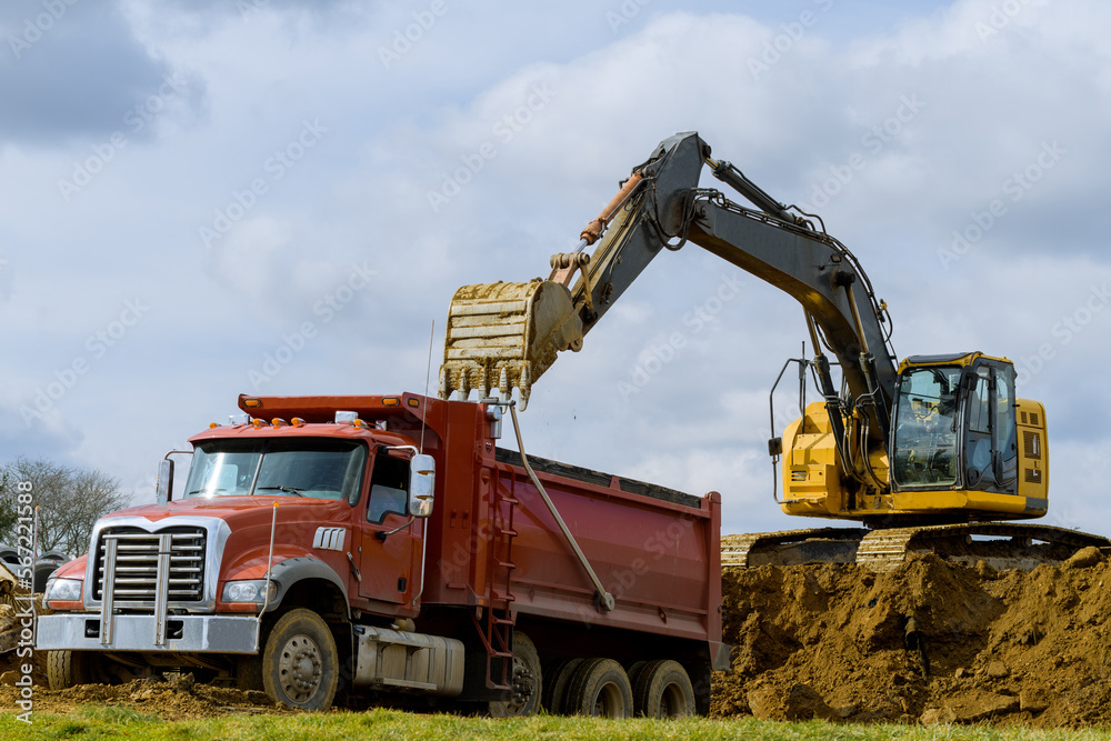 excavator loads earth onto big dump truck excavator loads earth onto big dump truck