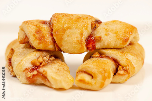 Rugelach cookies are made on cream cheese dough with strawberry jam, and mixed nuts topped with cinnamon sugar. 