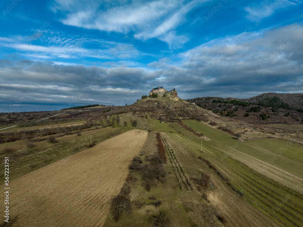 Aerial view of partially restored Boldogko, medieval Gothic castle in Borsod county Hungary with round gate tower, donjon cloudy blue sky background
