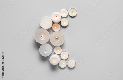 Crescent made of burning candles for Ramadan on grey background
