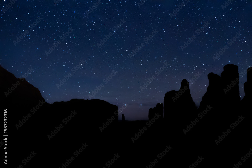 The night sky over the desert rock formations of Utah in Arches National Park.