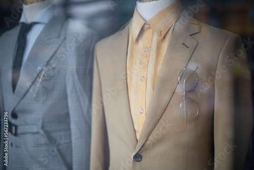 old fashioned men's suits through a shop window. Retro fashion with jackets, shirts and ties. photo
