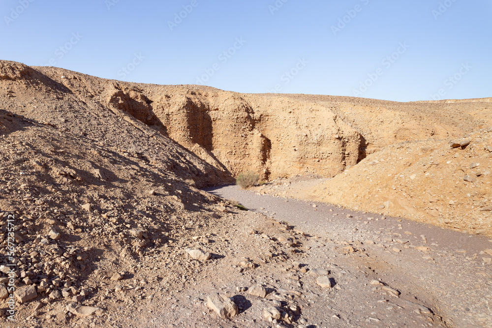 The dried  up river bed - the path to the Red Canyon, in the national reserve - the Red Canyon in the rays of the setting sun, near the city of Eilat, in southern Israel.