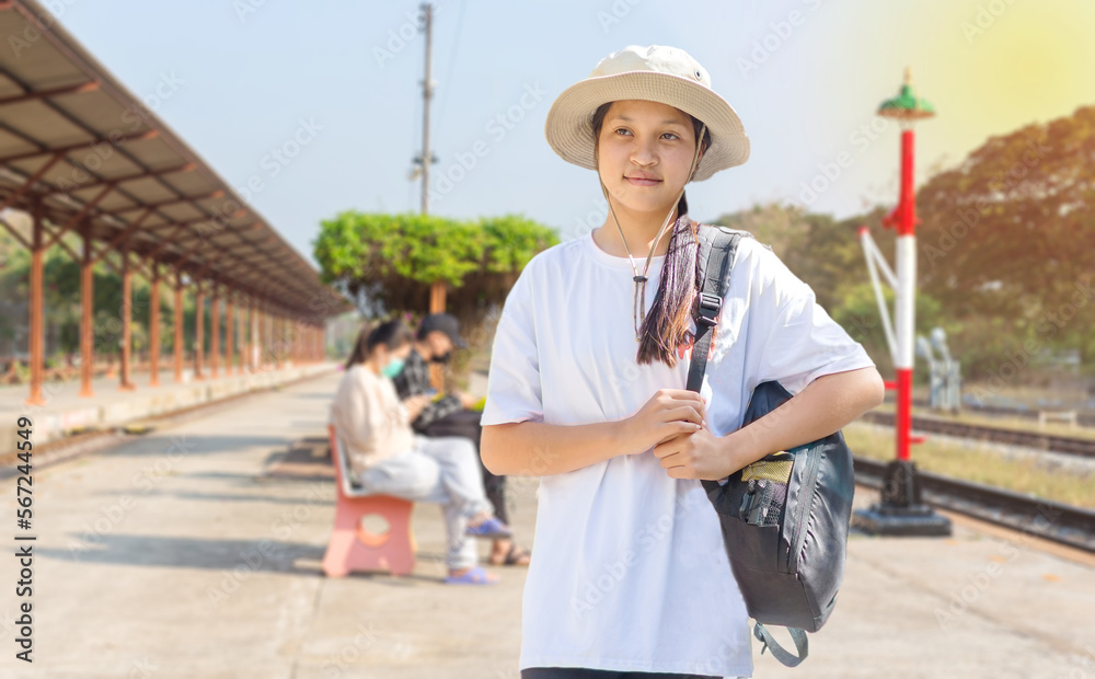 Portrait of an Asian girl holding a backpack at a train station