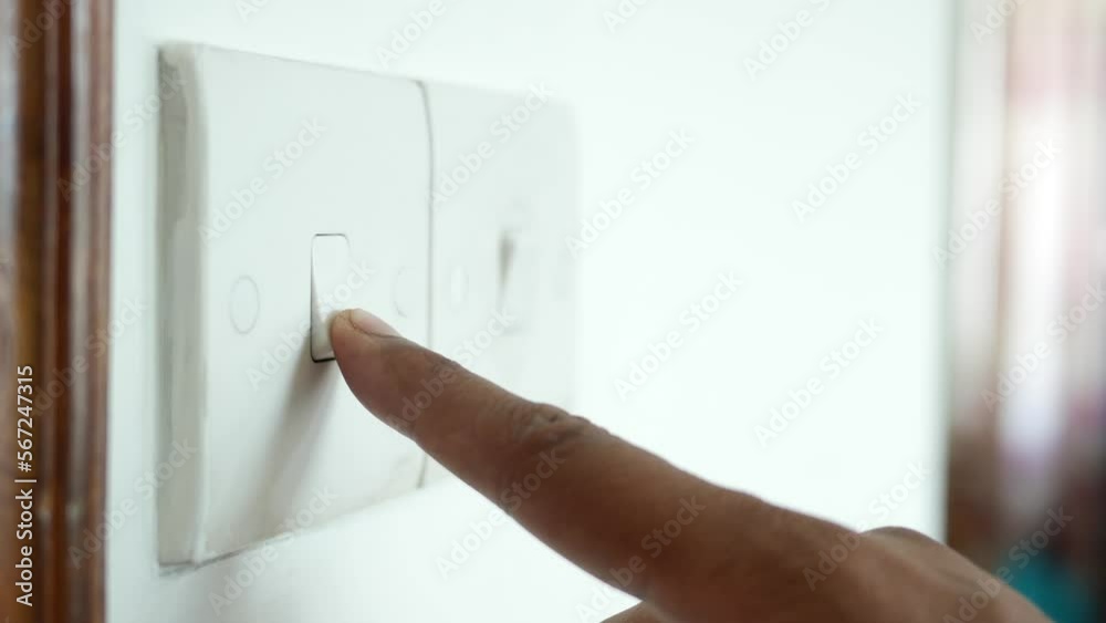 A finger turning on lighting switch .
