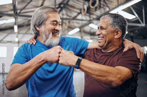 Men, gym and training with fist bump, smile and teamwork motivation for diversity, friends hug or happiness. Senior fitness partnership, asian and black man for mma workout, exercise or team building