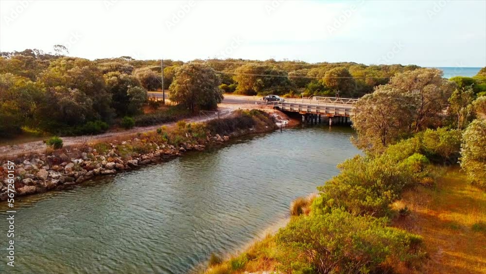 Drone view car driving on multi-lane bridge road over Vasse-Wonnerup river in western Australia. Beautiful aerial view panorama of wetlands and river flowing Drone view car driving on multi-lane bridge road over Vasse-Wonnerup river in western Australia. Beautiful aerial view panorama of wetlands and river flowing
