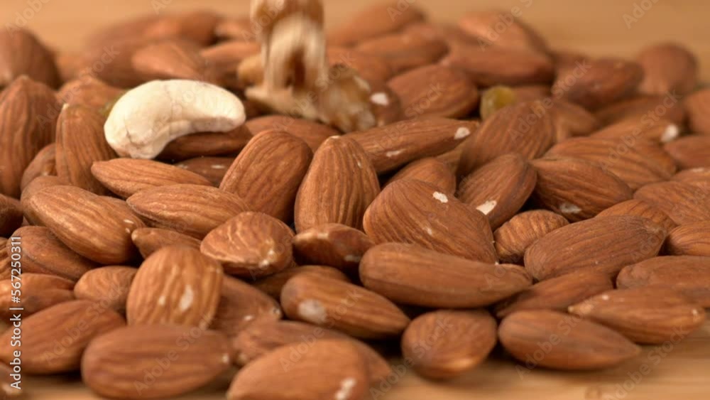 Closeup and slow motion shot of nuts. Almond nuts are a type of tree nut that are known for their slightly sweet  flavor. A popular snack food and are also used in a variety of culinary applications. 