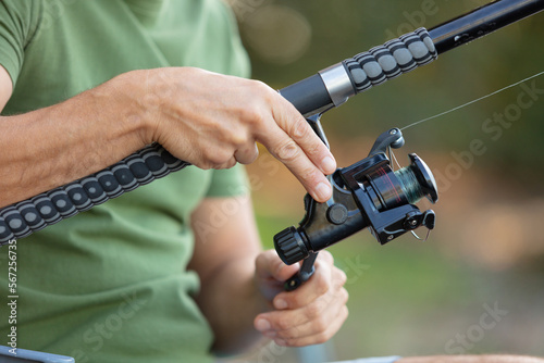 human hand holding fishing rod