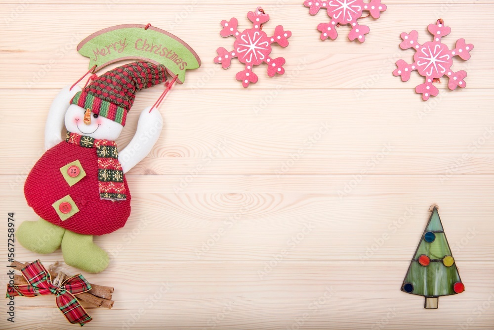 Obraz premium Happy New Year. Merry Christmas. New Year's card and copy space. Snowman, Christmas toys, Christmas tree and snowflakes as decoration. Background - textured wooden surface made of light wood.