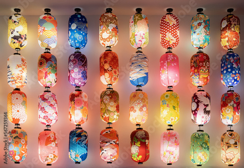 Various types of colorful Japanese lanterns hanging on the wall.