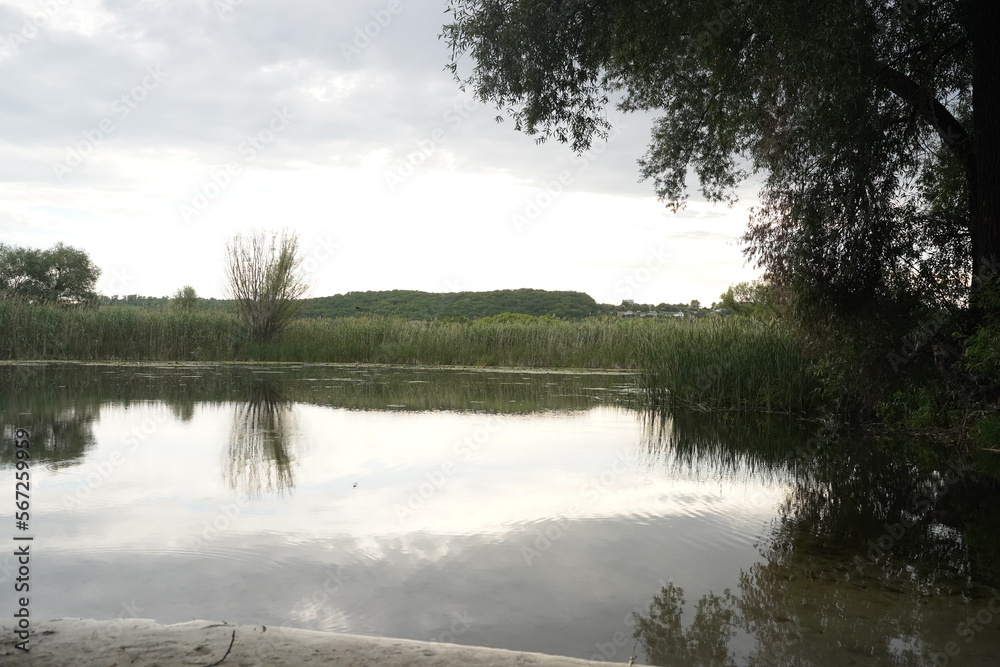 Fototapeta premium Cumulo nimbus clouds at sunset reflected in a lake
