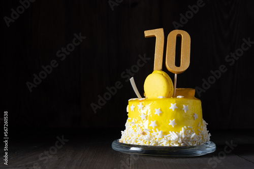 The number Seventy on a yellow cake for an anniversary or birthday in a dark key. photo