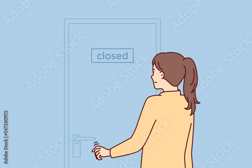Indecisive woman pulls hand to door with inscription closed stands with back to screen. Girl is discouraged and does not know what to do after store is closed due to bankruptcy